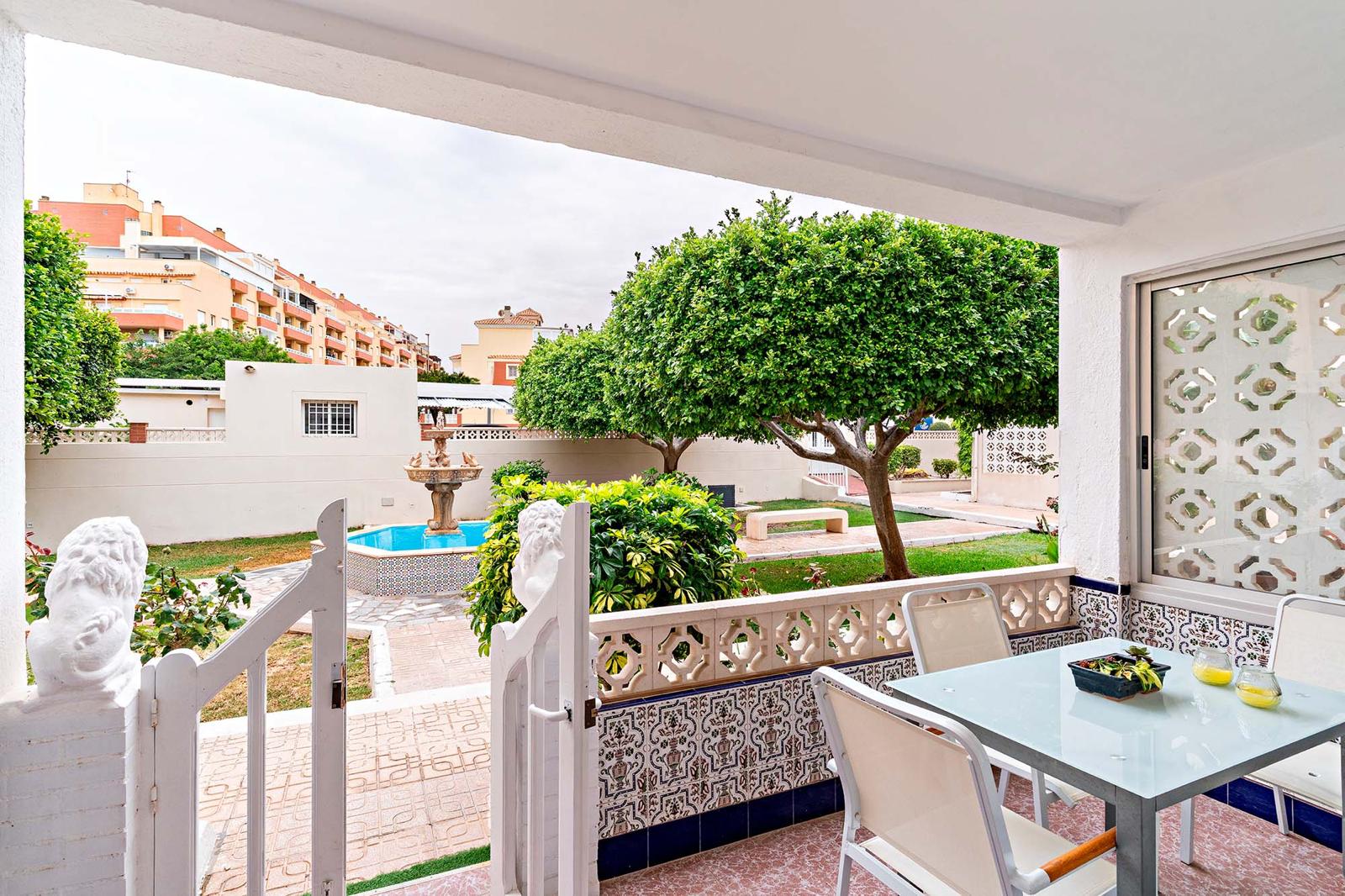 Terraza baja con mesa y acceso al jardín comunitario